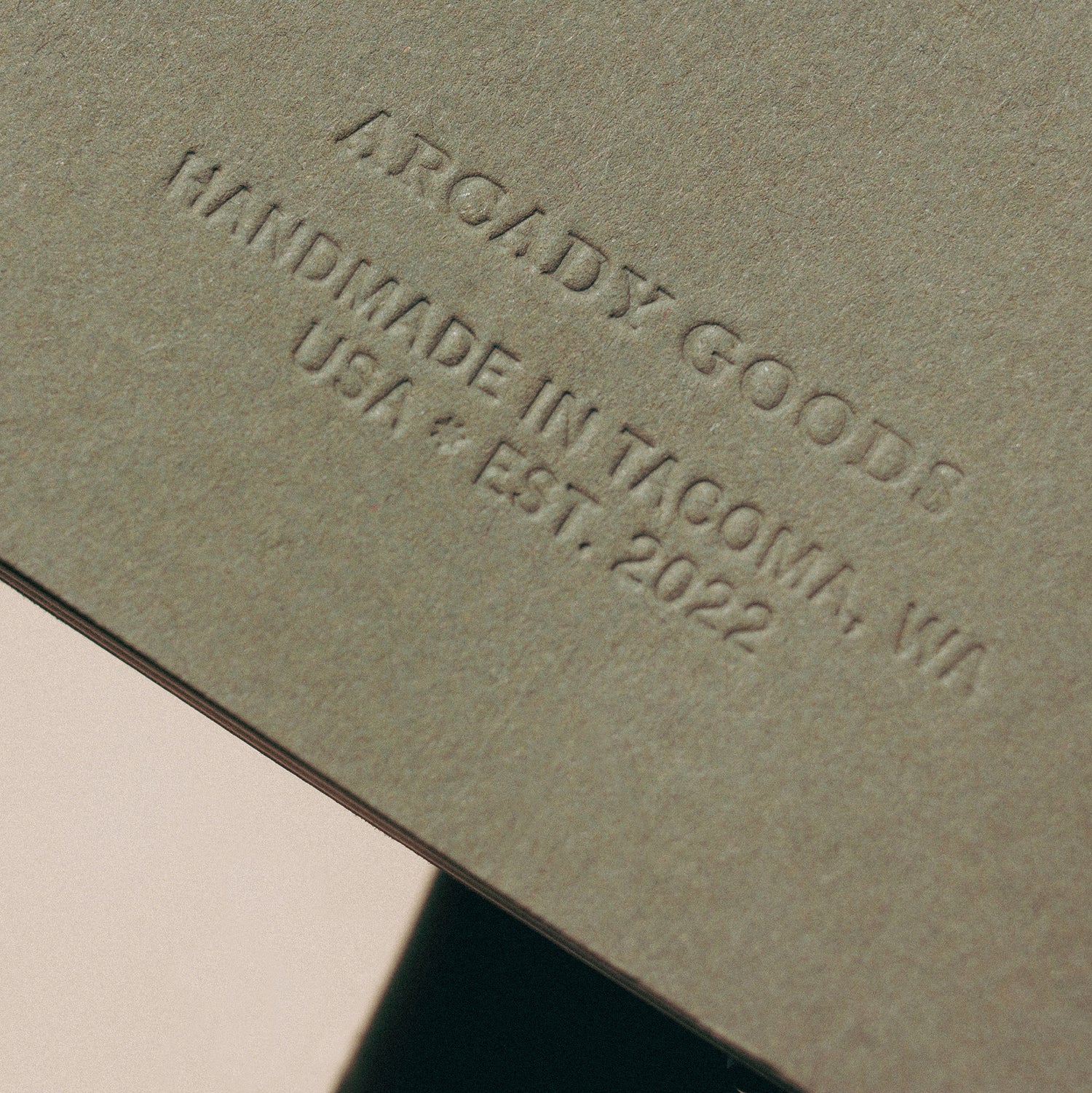 Back of an Arcady Goods notebook, embossed inscription reads "Arcady Goods. Handmade in Tacoma, Washington, USA. Established 2022."